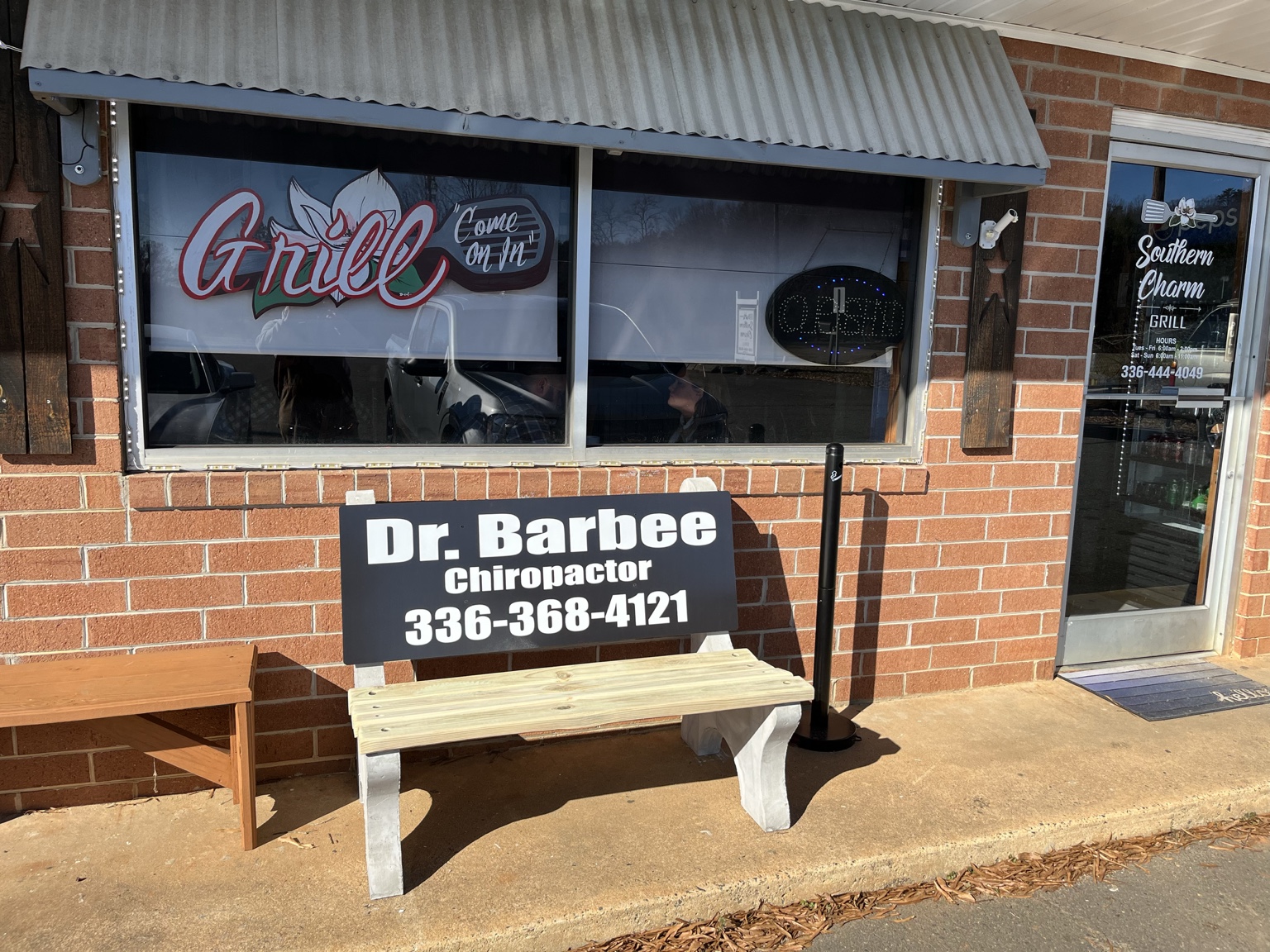 Chiropractor advertisement on a bench outside Southern Charm Grill
